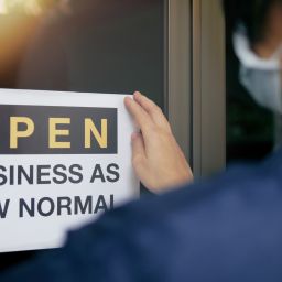 Sign showing a woman getting ready to re-open her business