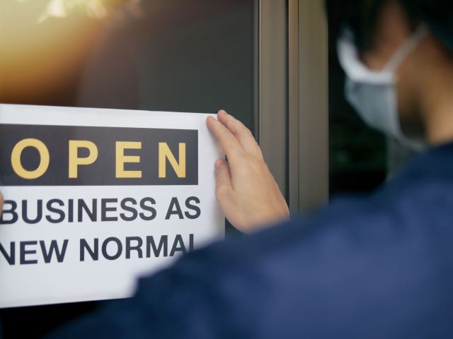 Sign showing a woman getting ready to re-open her business