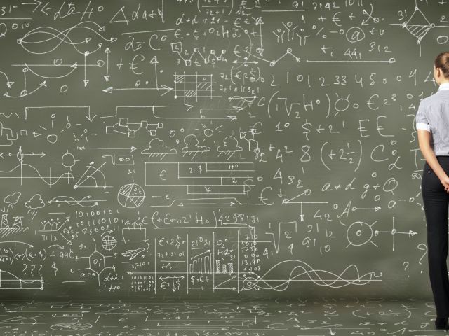 woman examining blackboard