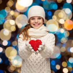Image of girl holding heart to signify giving
