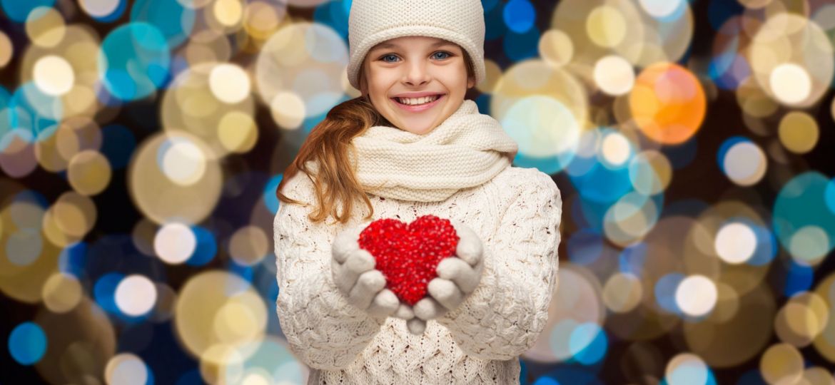 Image of girl holding heart to signify giving