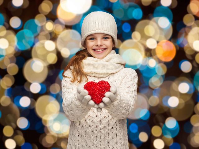 Image of girl holding heart to signify giving