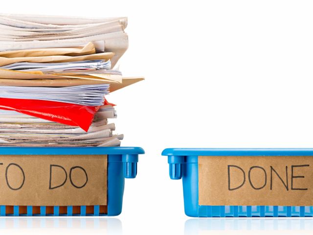 Procrastination - A full To Do tray and an empty Done tray - Overwhelmed - Isolated on white background