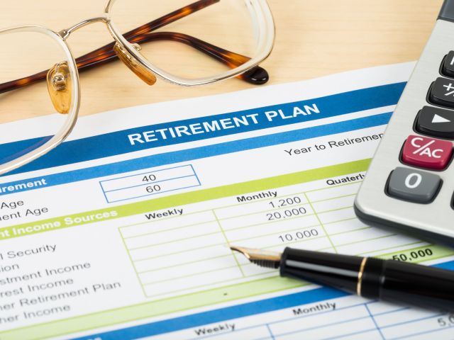 Retirement plan with glasses, pen, and calculator; document is mock-up
