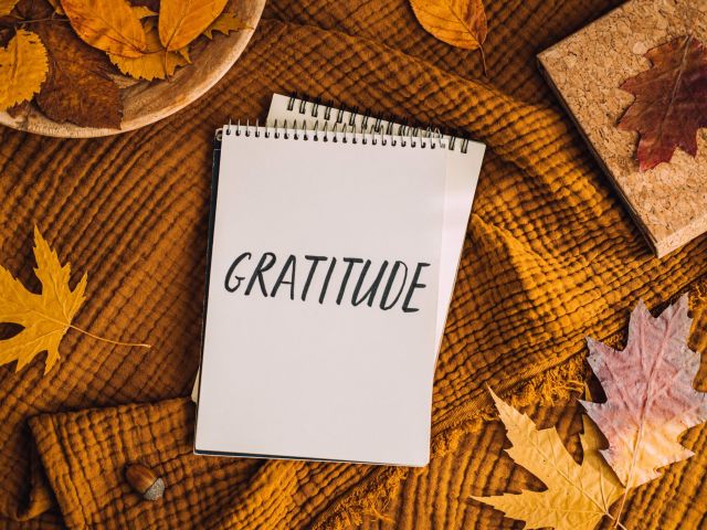 How to Practice Gratitude. Writing Autumn fall gratitude journal. Open paper notebook pages with Text gratitude and fall leaves brown bed. Notice appreciate good things, Express gratitude to yourself.